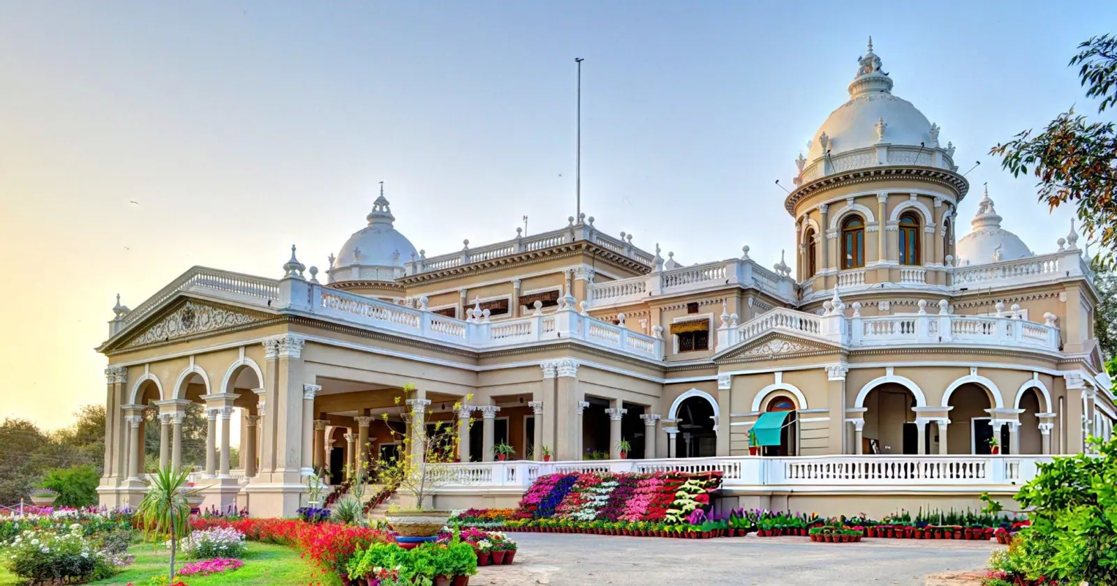 Gulzar Mahal palace in Bahawalpur — white and pastel facade with four circular domes, Corinthian columns, and overgrown courtyards